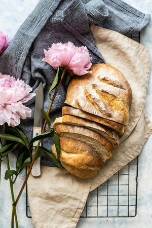 Voňavý kvasový chléb s křupavou kůrkou, položený na dřevěném prkénku a dokonalý food styling – pečeno s láskou od Mari Peče