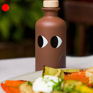 Detail prémiové láhve řeckého olivového oleje s lanýžovou infuzí.