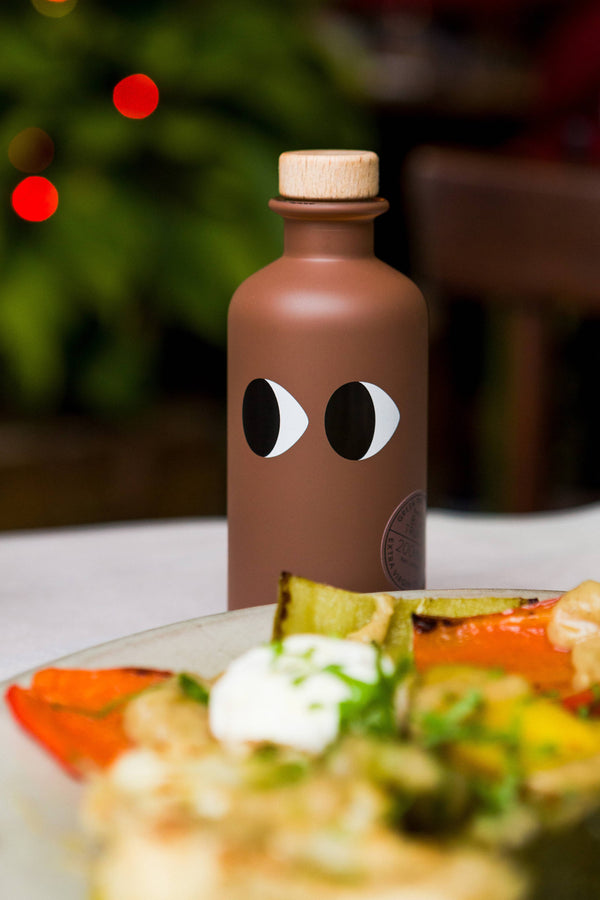 Detail prémiové láhve řeckého olivového oleje s lanýžovou infuzí.